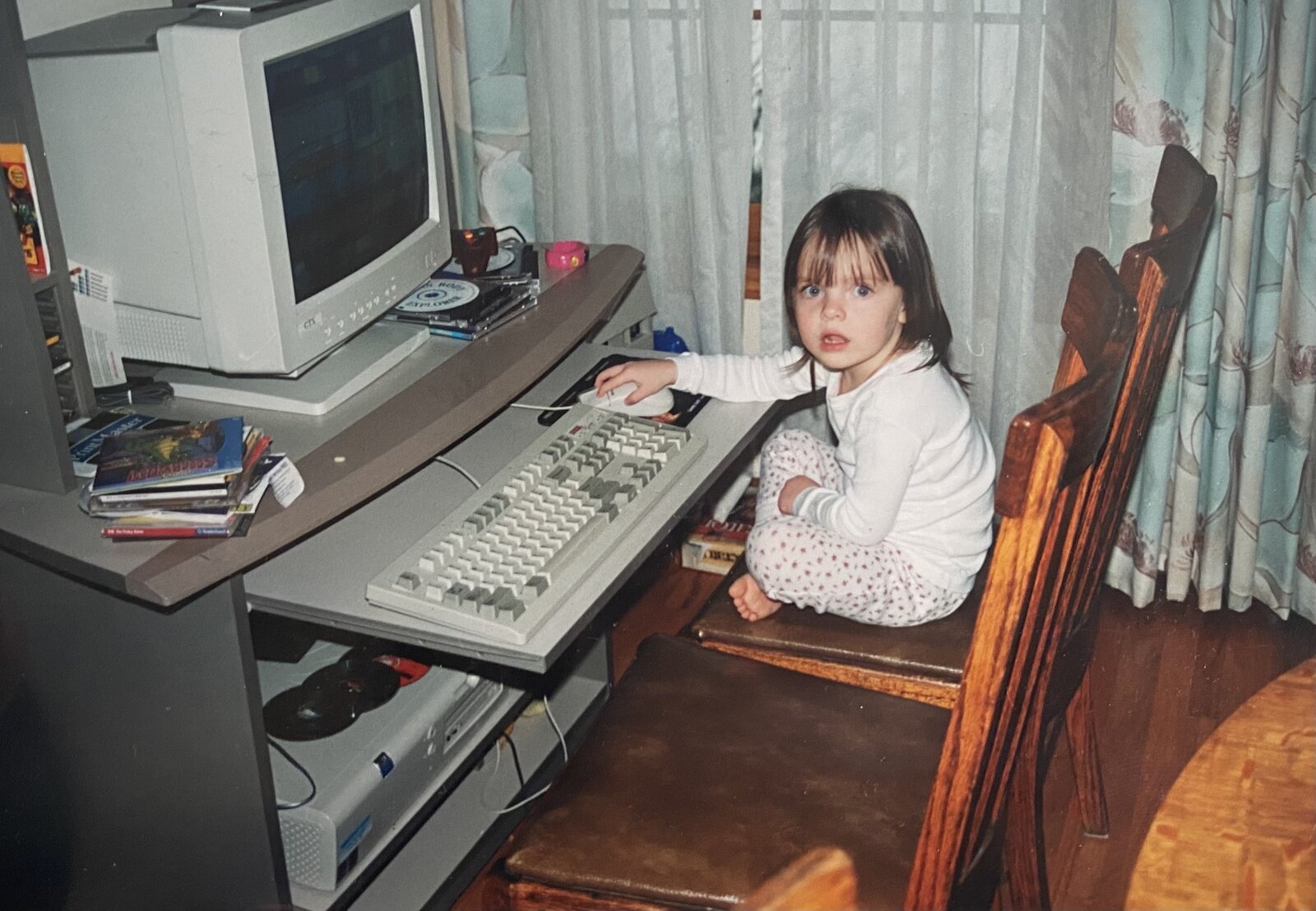 Bryn as a young child sitting at a 90s desktop computer.